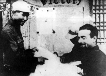 1936年8月12日，肖劲光（左）以红29军军长的身份，在宁夏预旺堡西征红军司令部同美国记者埃德加·斯诺亲切交谈。　